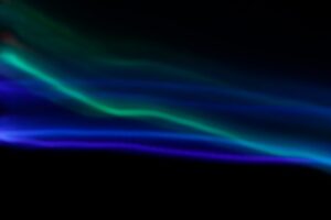Teal light trail across a dark background