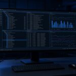 Monitor showing a tiling Linux desktop in a blue-lit lab
