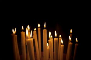 Rows of lit candles glowing in darkness