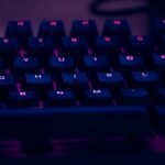 Backlit keyboard glowing purple and blue in the dark