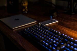 Keyboard and laptop on a dark desk