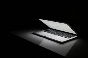 Open laptop glowing on a black background