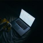 Laptop screen glowing in a dark room