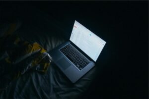 Laptop screen glowing in a dark room